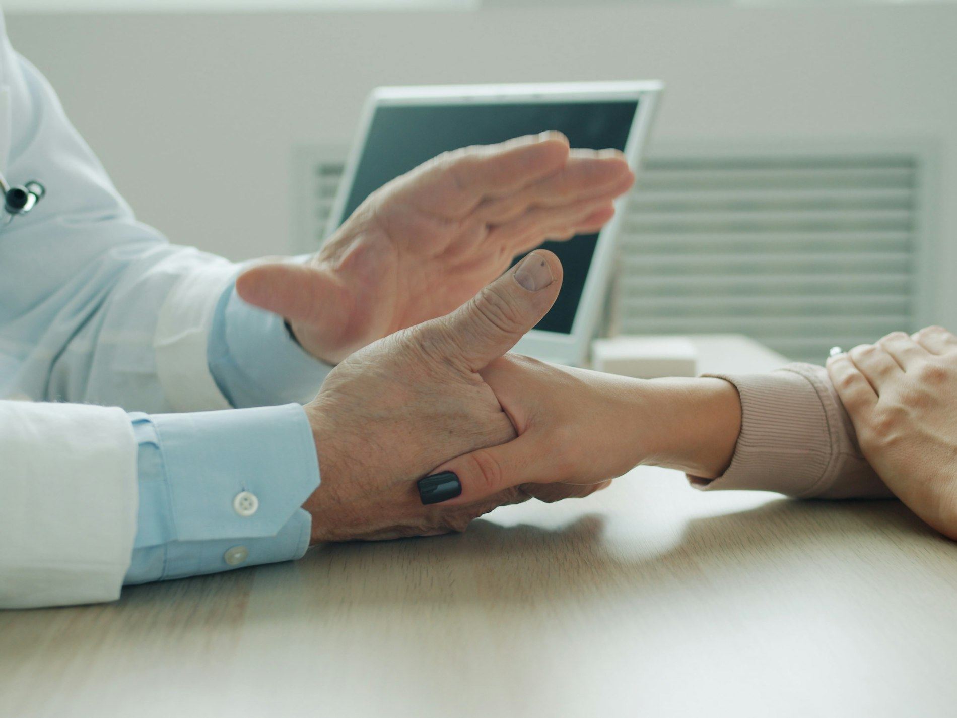 Hands fitting a hearing aid into an older man's ear